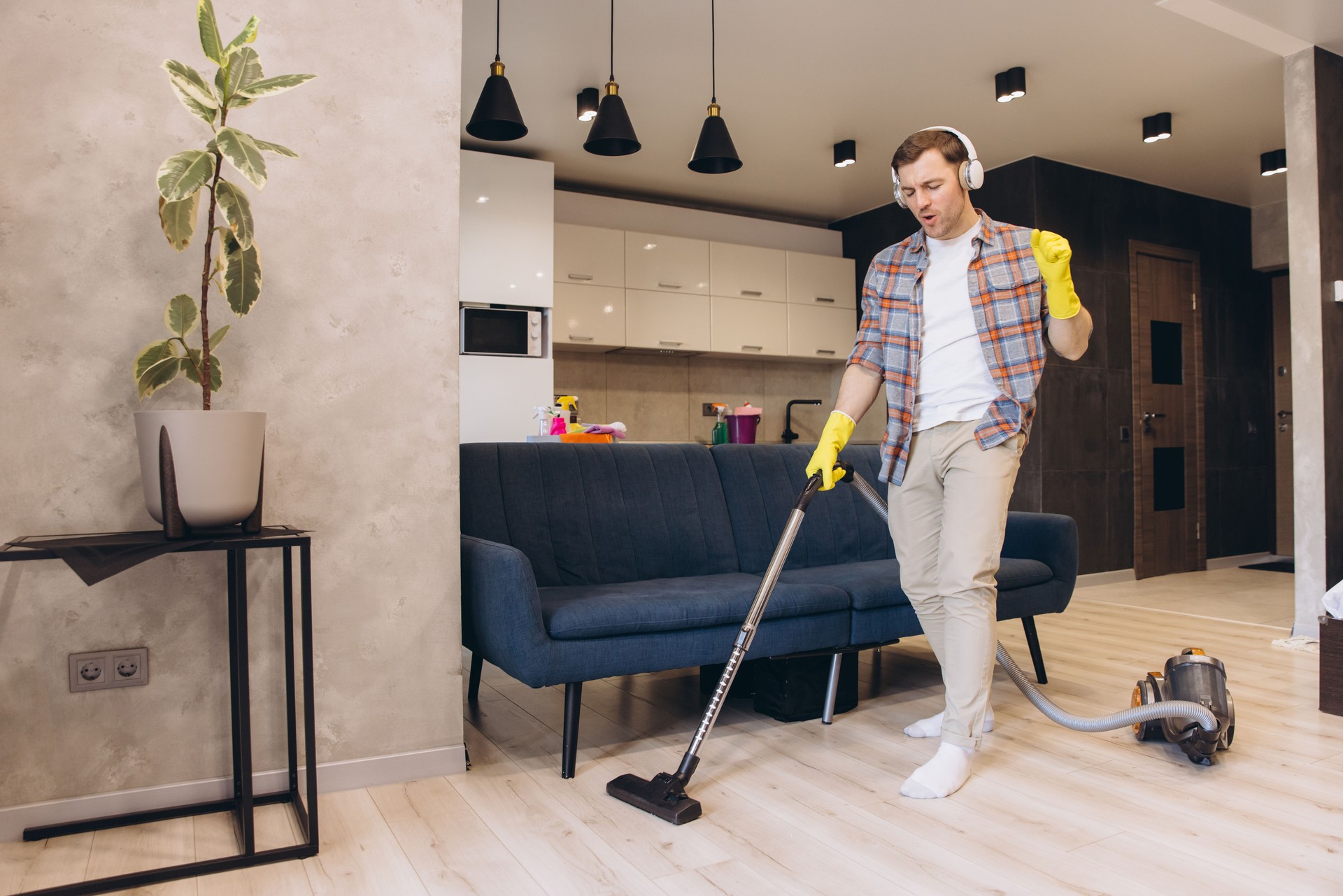Man Vacuuming and Dancing in Living Room Listening Music with Headphones